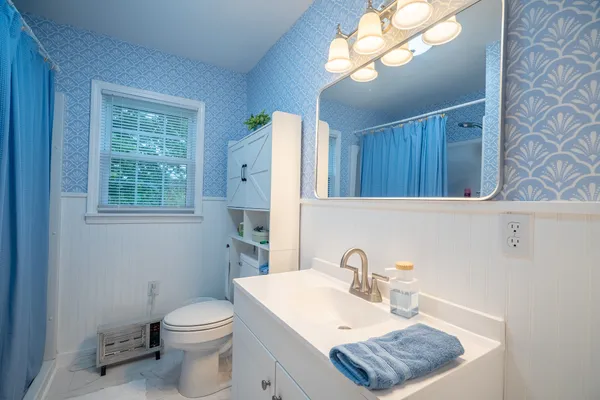 a bathroom with a sink a toilet and a mirror