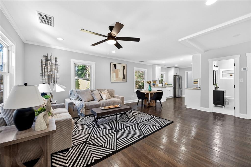 a living room with furniture and a wooden floor