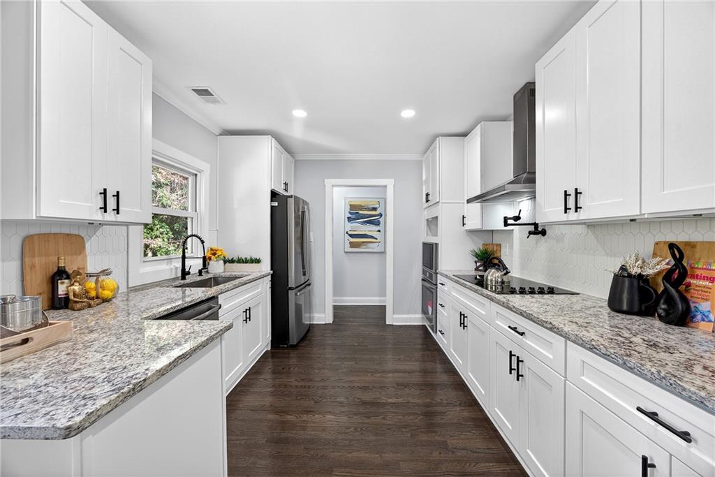 430 Wilkinson Drive Southeast Atlanta, GA 30317 - Photo 15 of 28 a large kitchen with stainless steel appliances granite countertop a lot of counter space and wooden floor