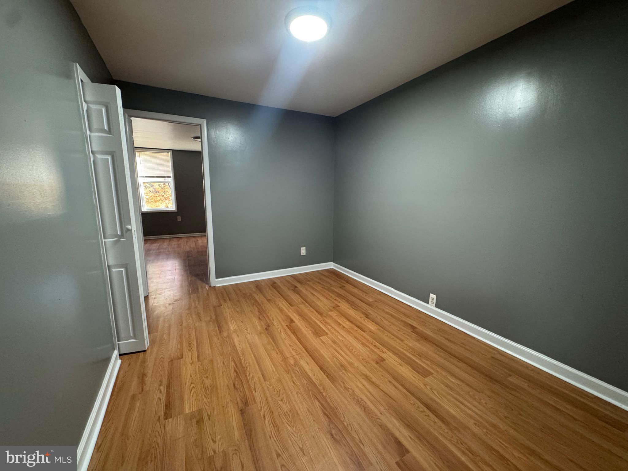 2408 Wilkens Avenue Baltimore, MD 21223 - Photo 11 of 26 an empty room with wooden floor and windows