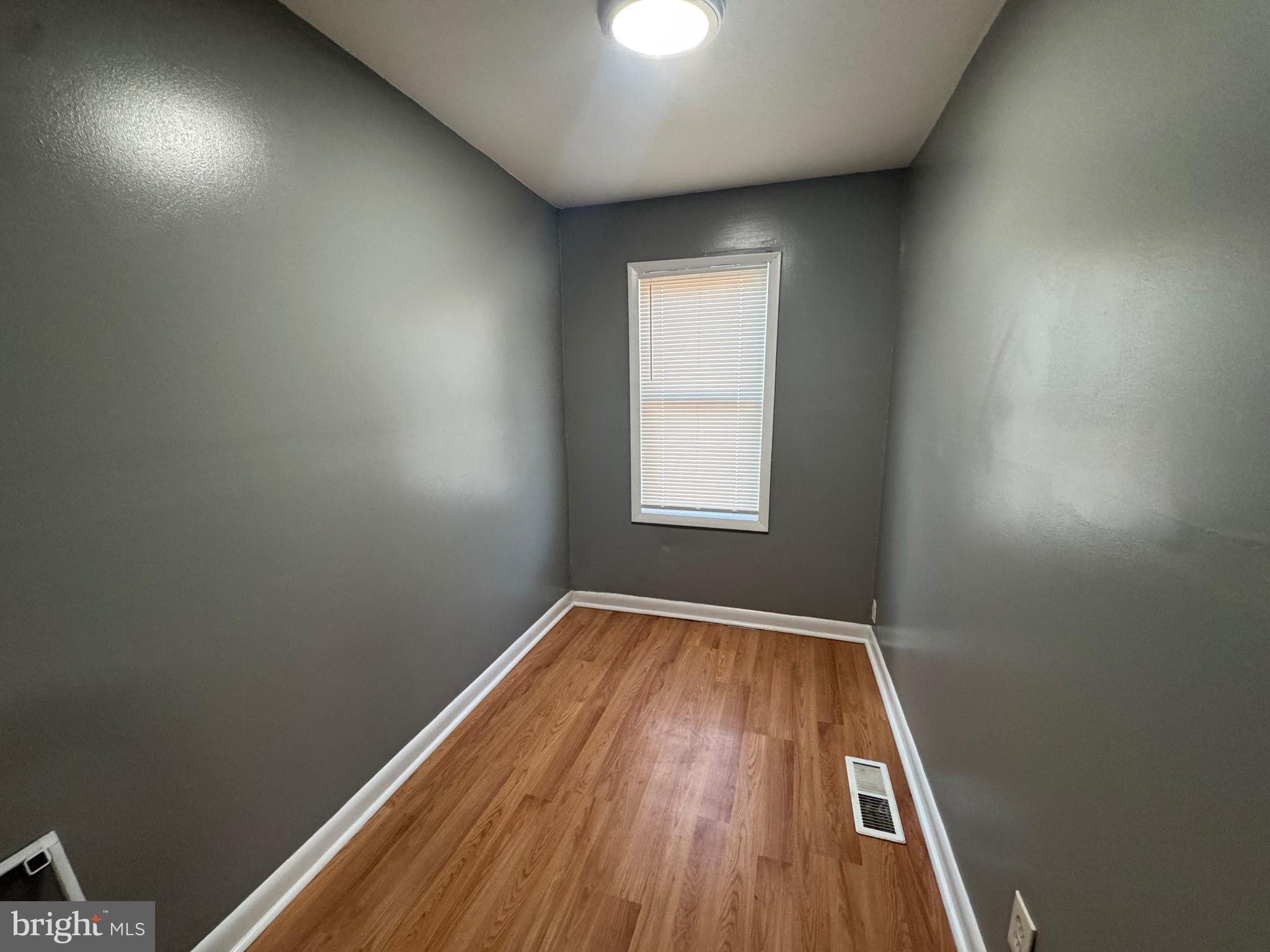 2408 Wilkens Avenue Baltimore, MD 21223 - Photo 12 of 26 an empty room with wooden floor and windows