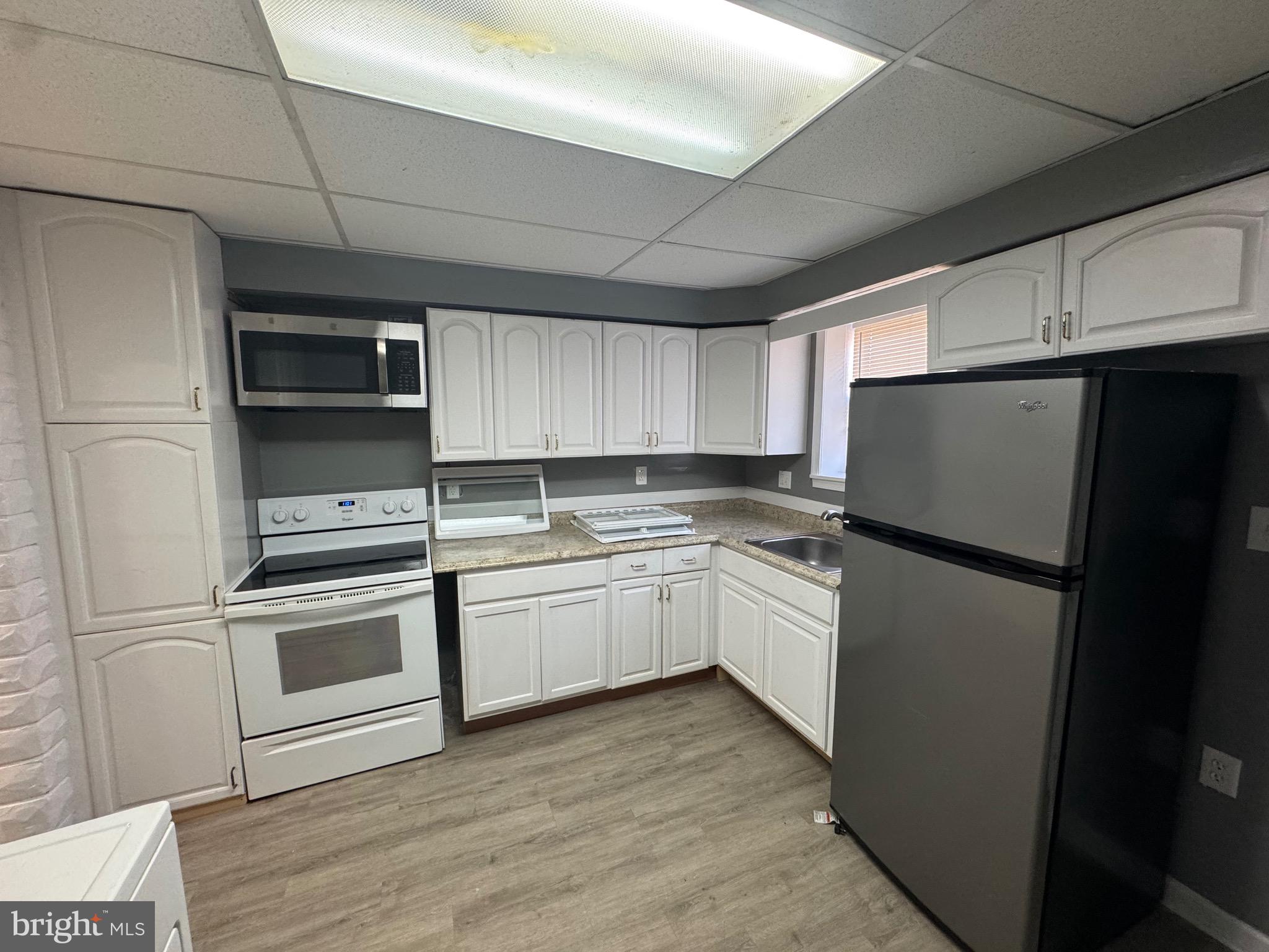 2408 Wilkens Avenue Baltimore, MD 21223 - Photo 2 of 26 a kitchen with a refrigerator sink and microwave
