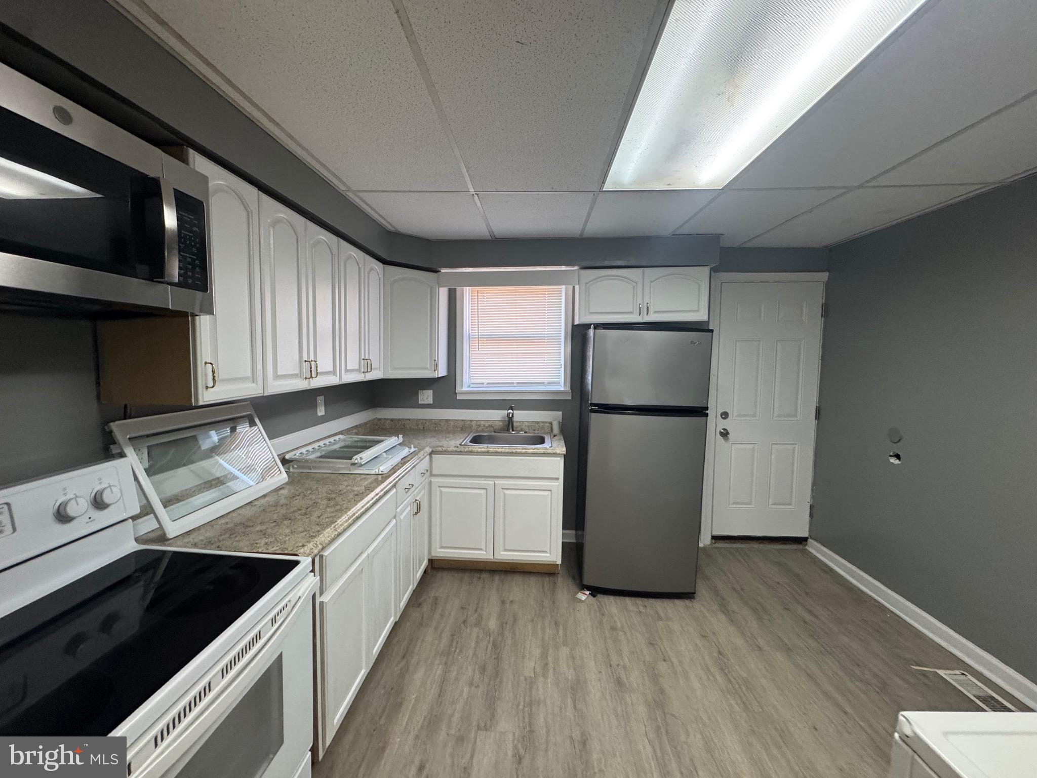 2408 Wilkens Avenue Baltimore, MD 21223 - Photo 21 of 26 a kitchen with a refrigerator sink and cabinets