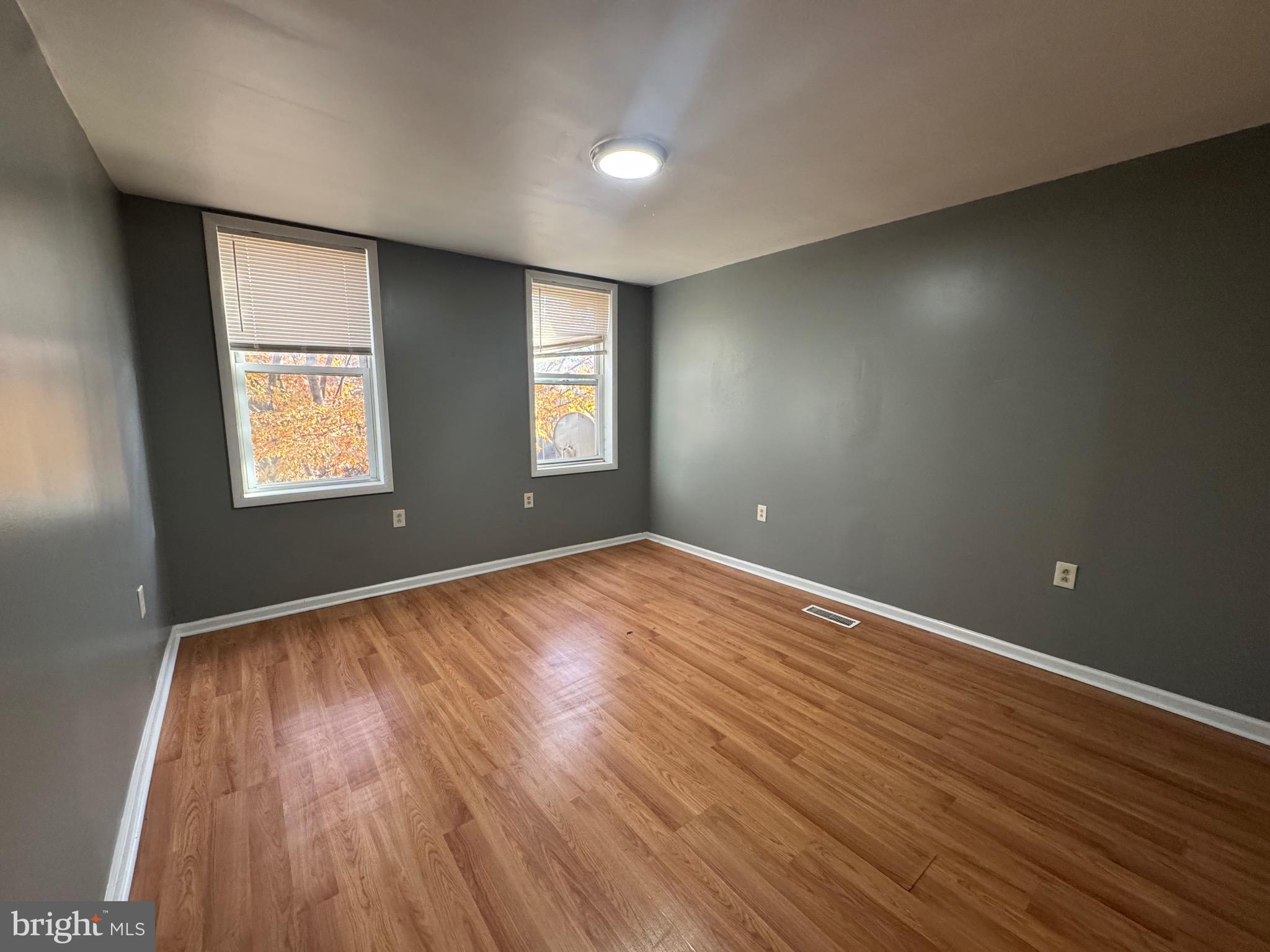 2408 Wilkens Avenue Baltimore, MD 21223 - Photo 5 of 26 an empty room with wooden floor and windows