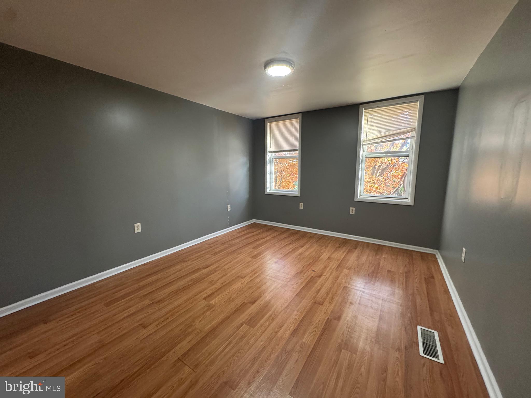 2408 Wilkens Avenue Baltimore, MD 21223 - Photo 6 of 26 an empty room with wooden floor and windows