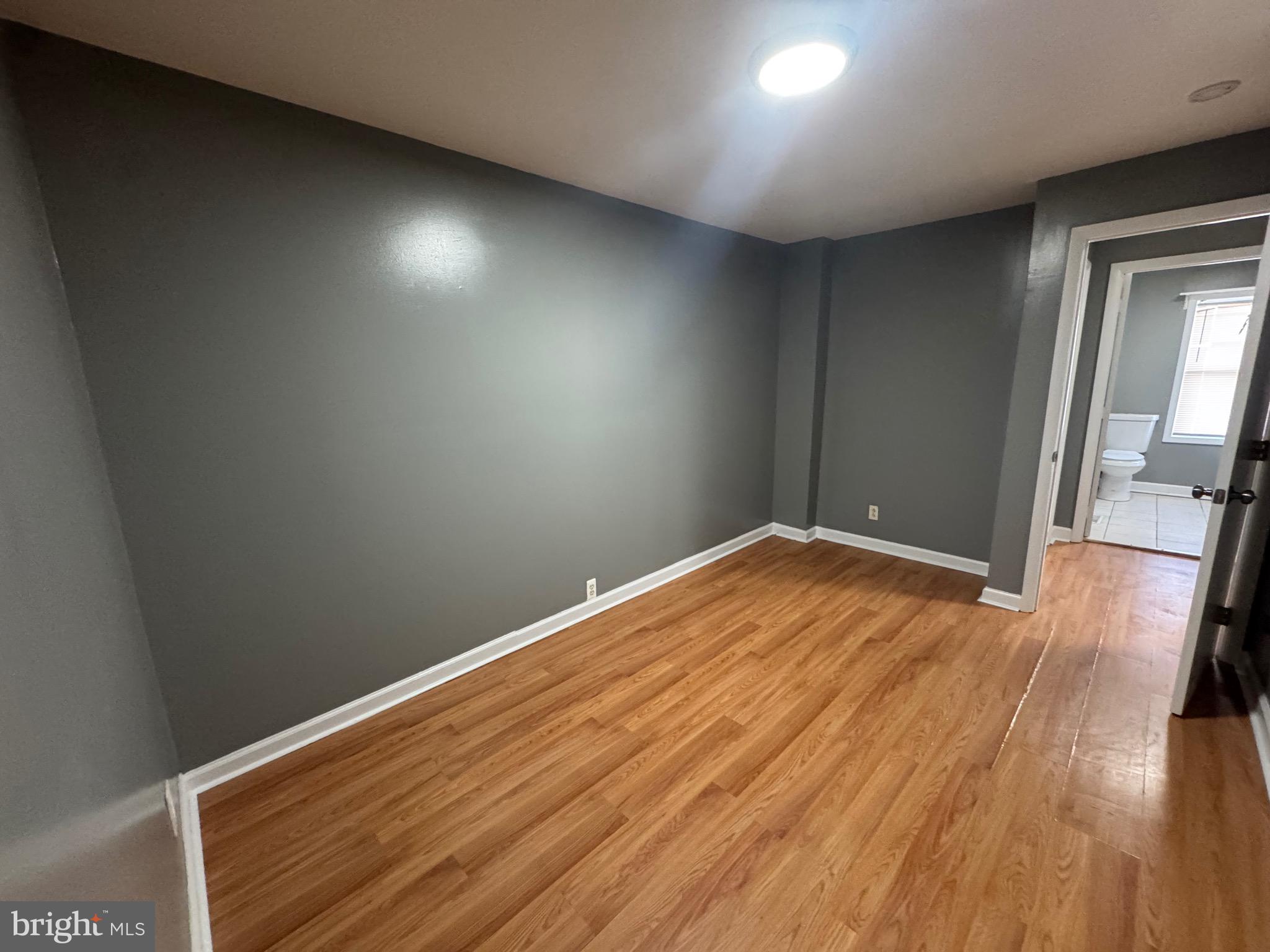 2408 Wilkens Avenue Baltimore, MD 21223 - Photo 8 of 26 an empty room with wooden floor and windows