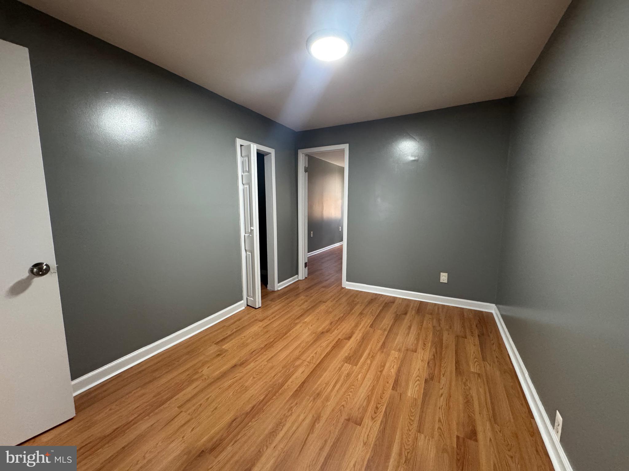 2408 Wilkens Avenue Baltimore, MD 21223 - Photo 10 of 26 an empty room with wooden floor and windows