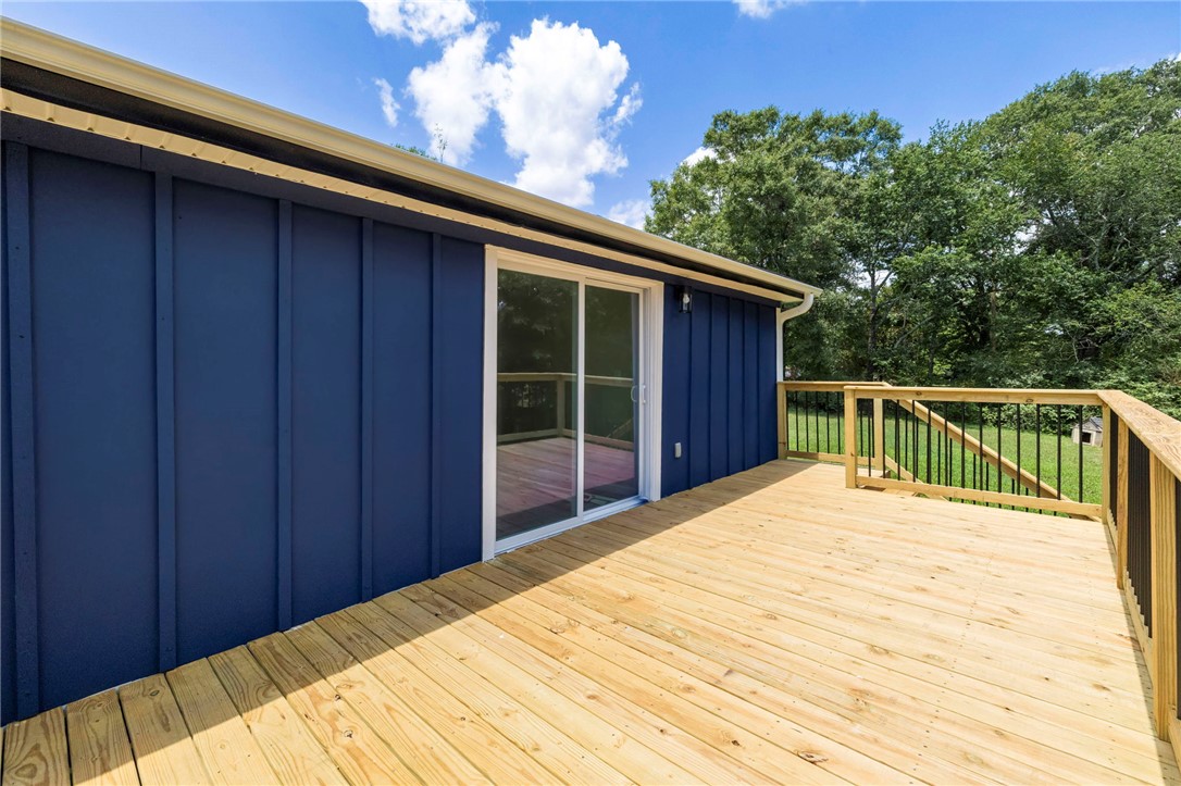 418 Old River Road Pelzer, SC 29669 - Photo 25 of 29 A spacious wooden deck extends from a vibrant blue exterior, perfect for outdoor enjoyment.