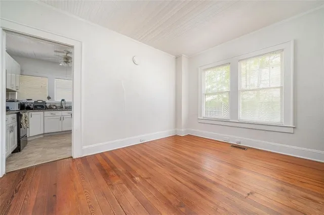 an empty room with wooden floor and windows