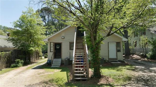 a view of a yard with plants and large trees