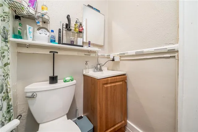 a bathroom with a toilet sink and mirror