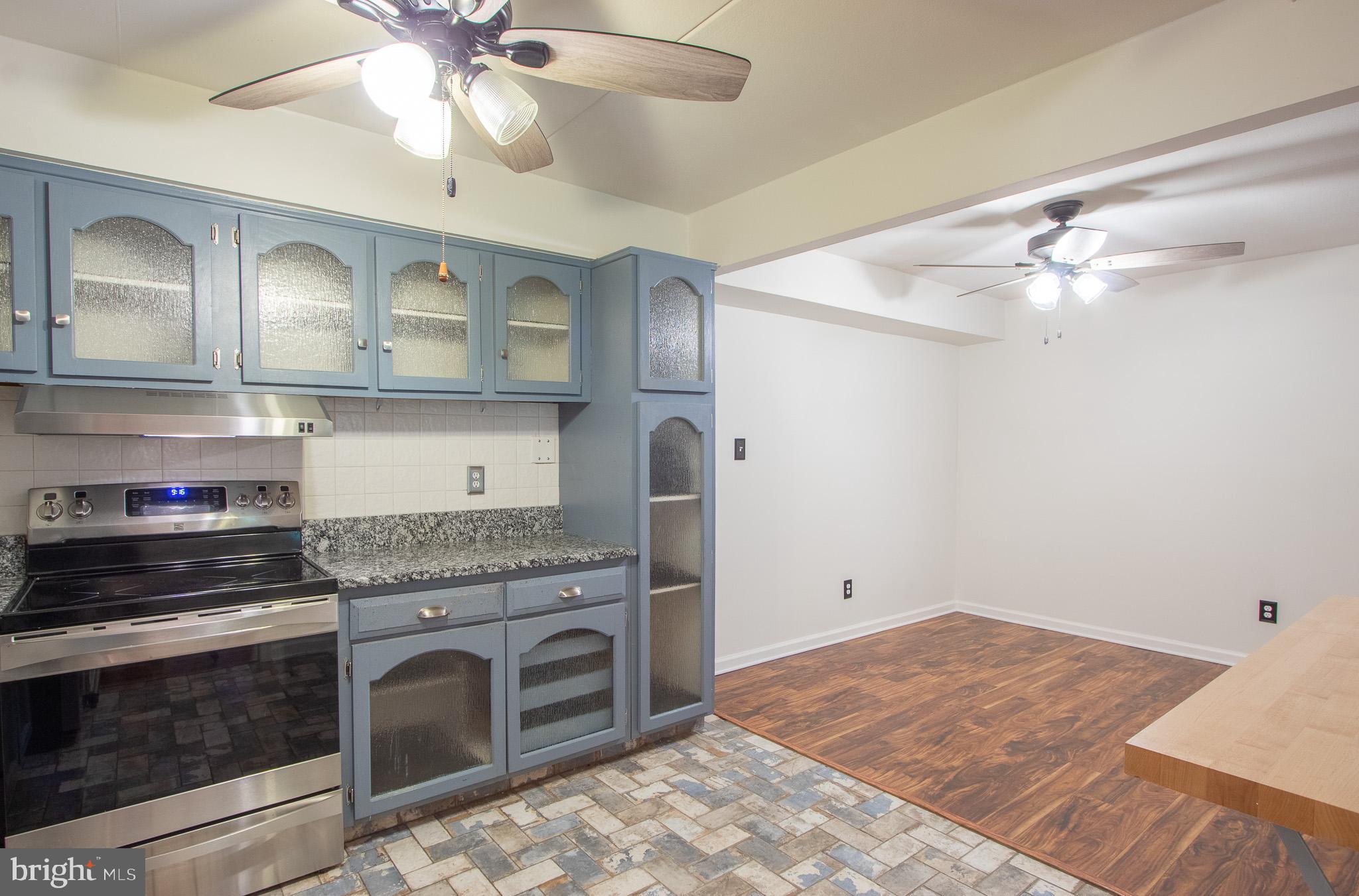 76 Welsh Tract Road, Unit F109 Newark, DE 19713 - Photo 11 of 31 a kitchen with stainless steel appliances granite countertop a stove and a sink with cabinets