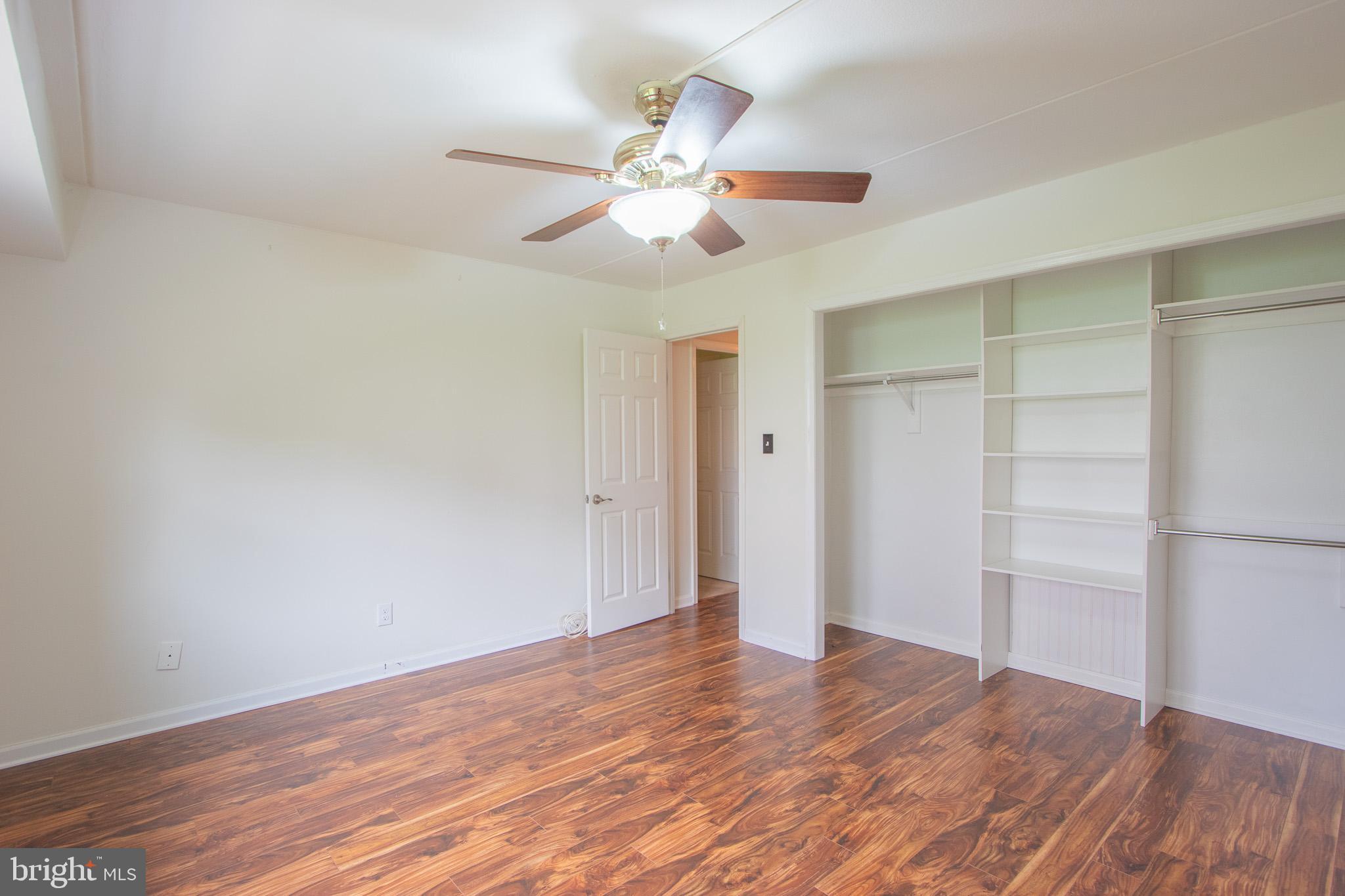 76 Welsh Tract Road, Unit F109 Newark, DE 19713 - Photo 24 of 31 an empty room with wooden floor closet fan and windows