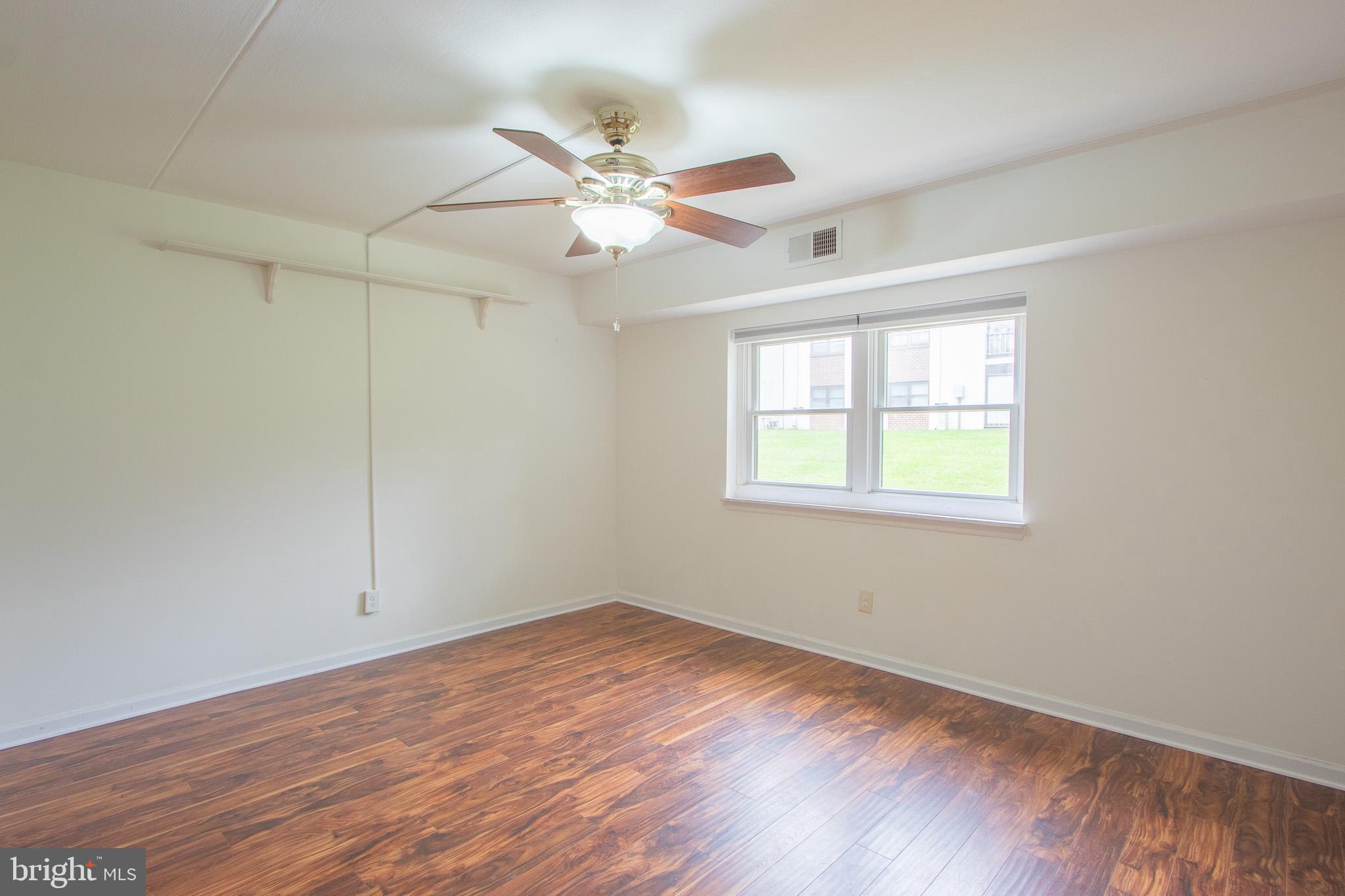 76 Welsh Tract Road, Unit F109 Newark, DE 19713 - Photo 26 of 31 an empty room with wooden floor fan and windows