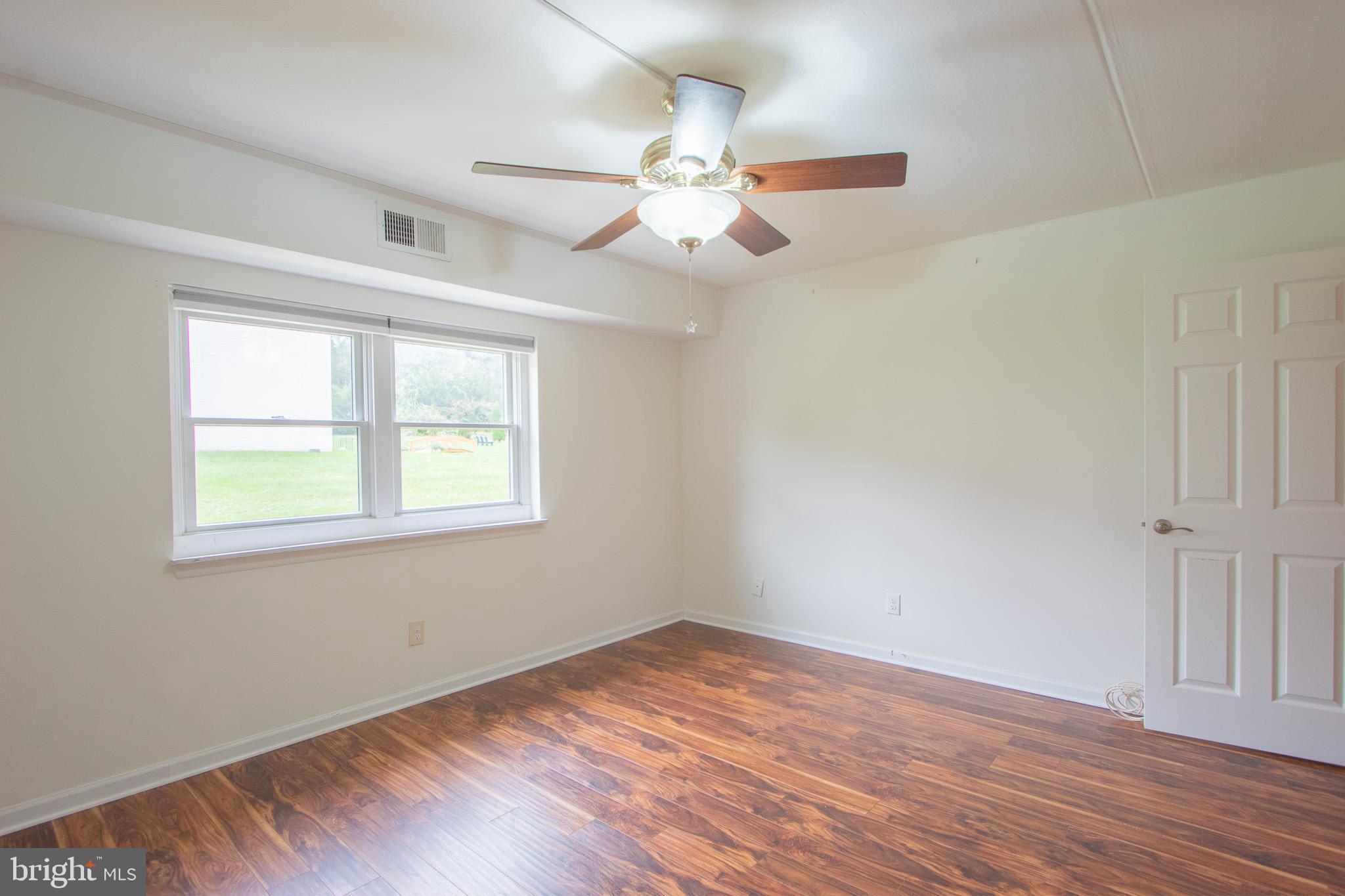 76 Welsh Tract Road, Unit F109 Newark, DE 19713 - Photo 27 of 31 an empty room with wooden floor fan and windows