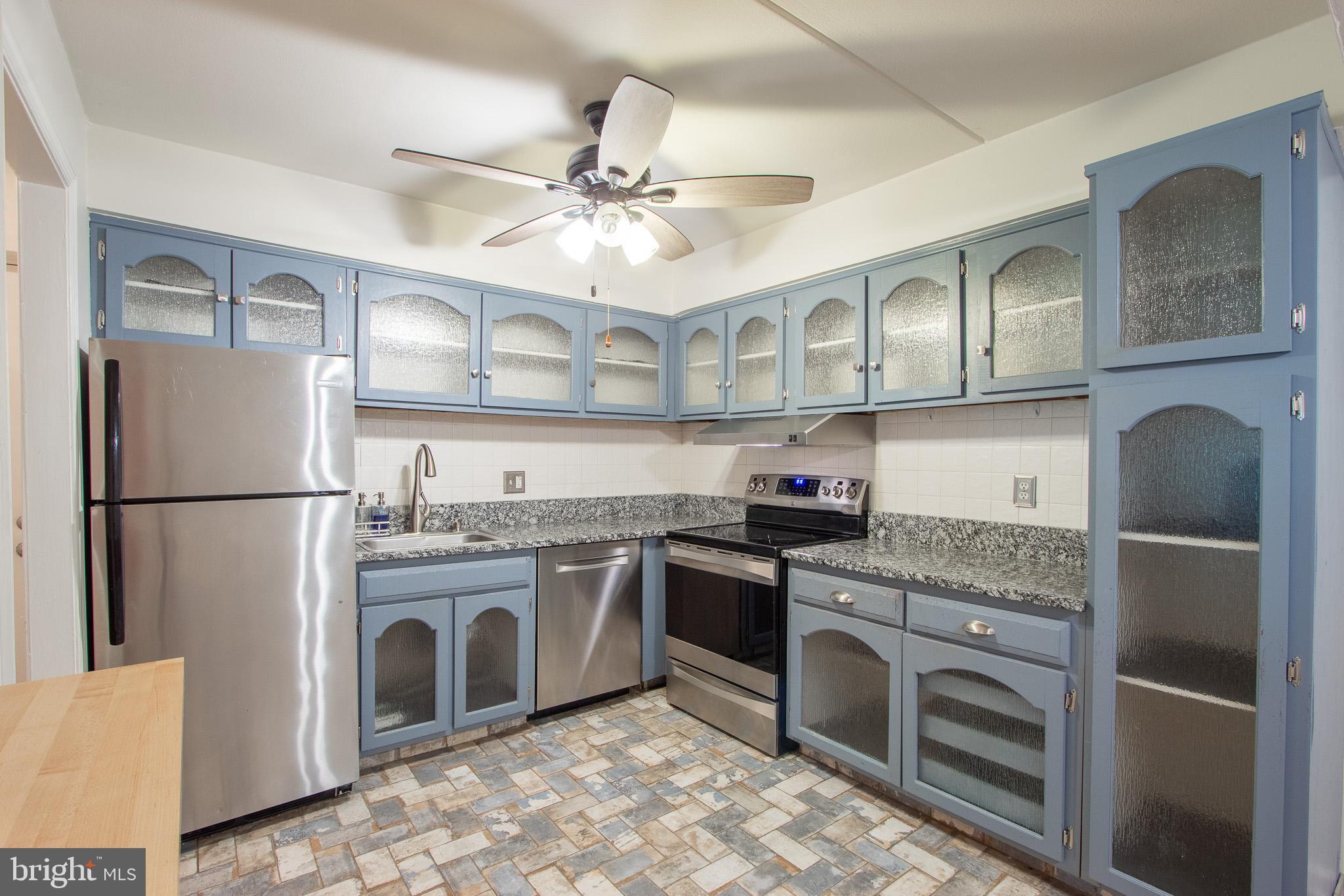 76 Welsh Tract Road, Unit F109 Newark, DE 19713 - Photo 9 of 31 a kitchen with stainless steel appliances granite countertop a refrigerator a stove a sink and dishwasher