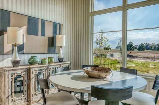 a dining room with furniture a rug and a large window