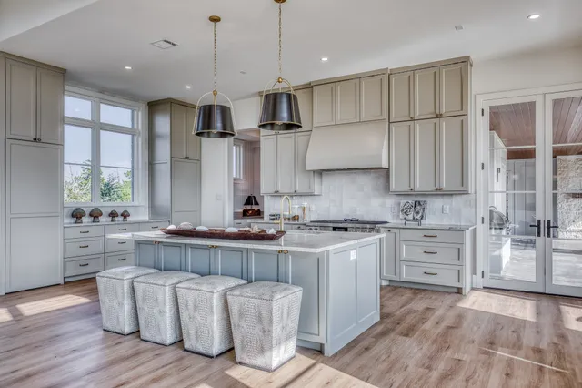a large kitchen with cabinets wooden floor and stainless steel appliances