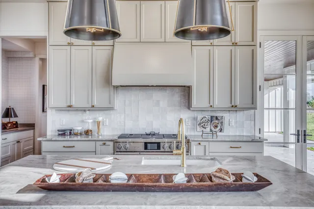 a kitchen with stainless steel appliances granite countertop a sink and a white cabinets