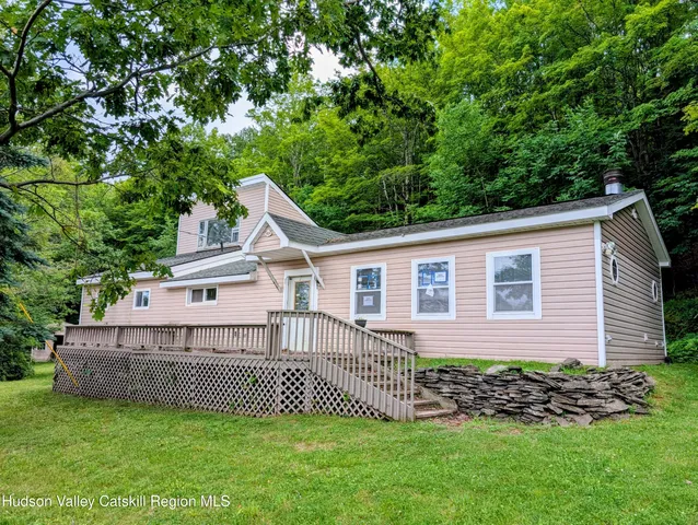 a view of a house with a yard and deck