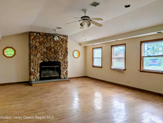 a view of an empty room with a fireplace and a window