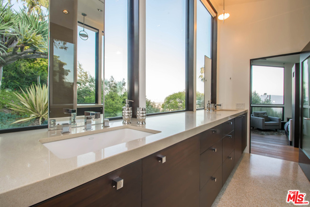 1440 North Kings Road Los Angeles, CA 90069 - Photo 17 of 37 a bathroom with a double vanity sink and a large mirror next to a window
