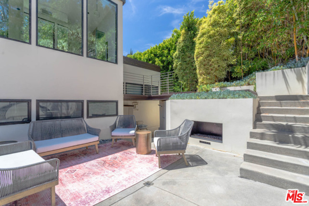 1440 North Kings Road Los Angeles, CA 90069 - Photo 33 of 37 a view of backyard with seating space and trees in the background