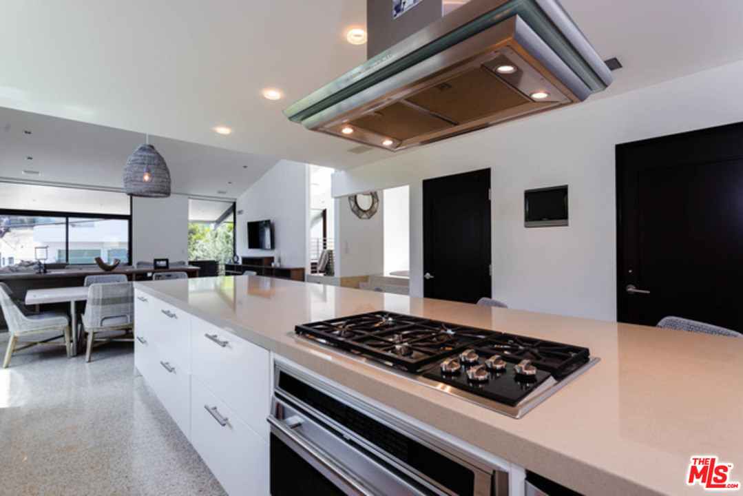 1440 North Kings Road Los Angeles, CA 90069 - Photo 9 of 37 a kitchen with a stove and white cabinets