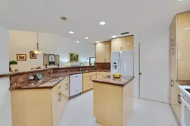 a kitchen with stainless steel appliances granite countertop a sink and a refrigerator