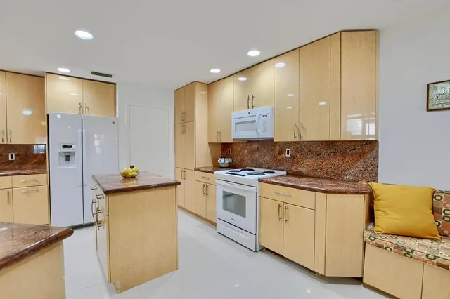 a kitchen with stainless steel appliances granite countertop a stove and a refrigerator