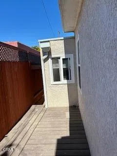 a walk in closet with wooden floor