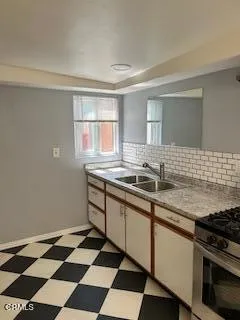 a kitchen with a sink stove and cabinets