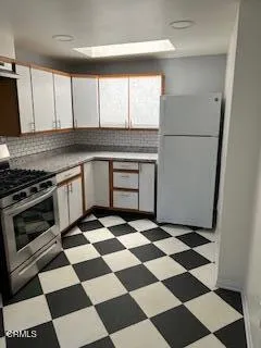 a kitchen with a checkered floor and white cabinets