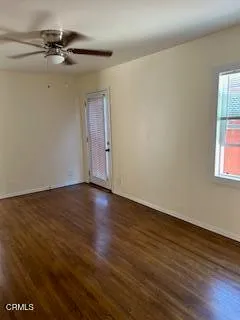 a view of empty room with wooden floor