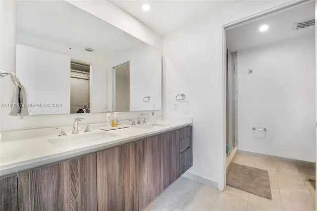 a bathroom with a tub shower vanity and a sink