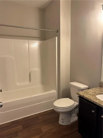 a bathroom with a granite countertop toilet and a shower