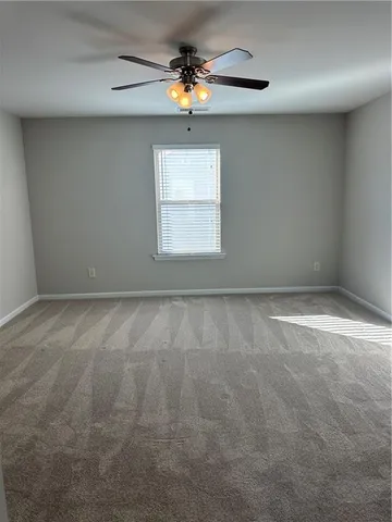 en empty room with windows and fan