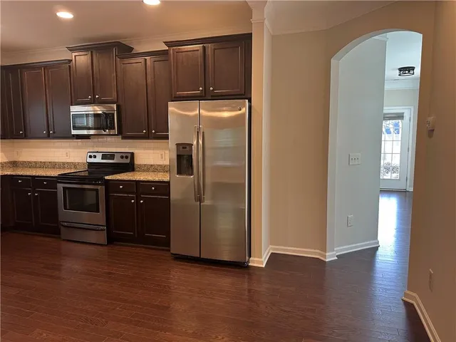 a kitchen with stainless steel appliances granite countertop a refrigerator microwave and sink