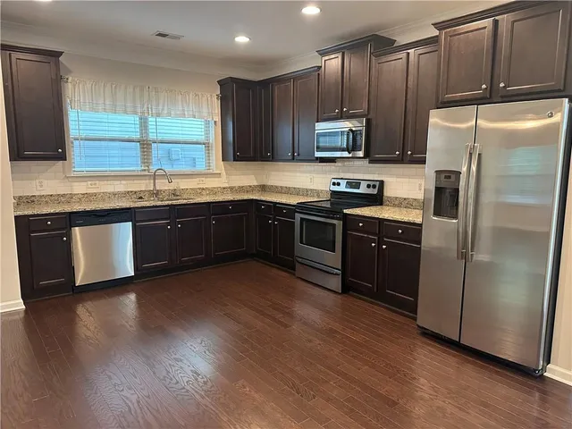 a kitchen with wooden cabinets stainless steel appliances and a window