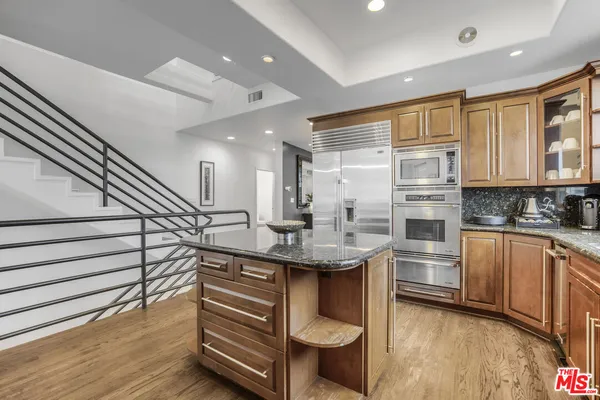 a kitchen with stainless steel appliances granite countertop a sink and cabinets