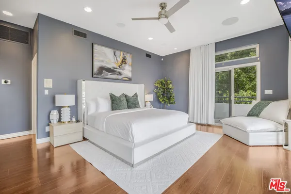 a bedroom with a large bed and a chandelier
