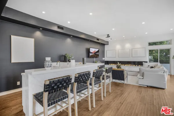 a kitchen with a table chairs stove and wooden floor