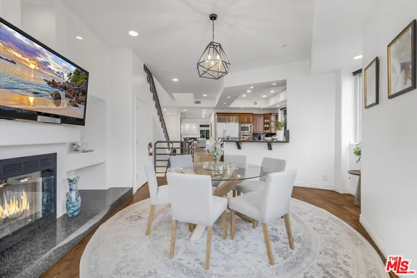 a view of a dining room with furniture wooden floor and a fireplace