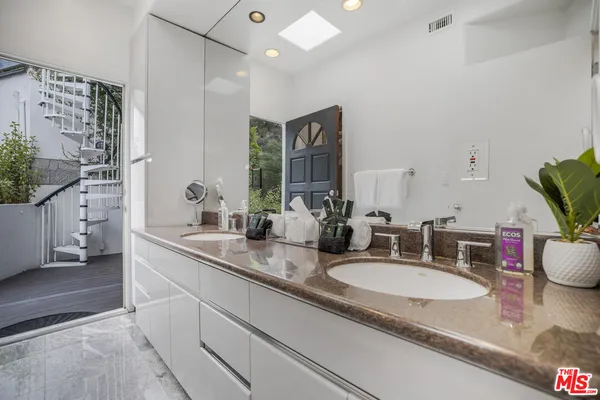 a bathroom with double sink and a mirror