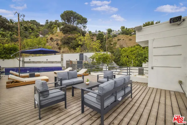 a view of a rooftop deck with couch and chairs