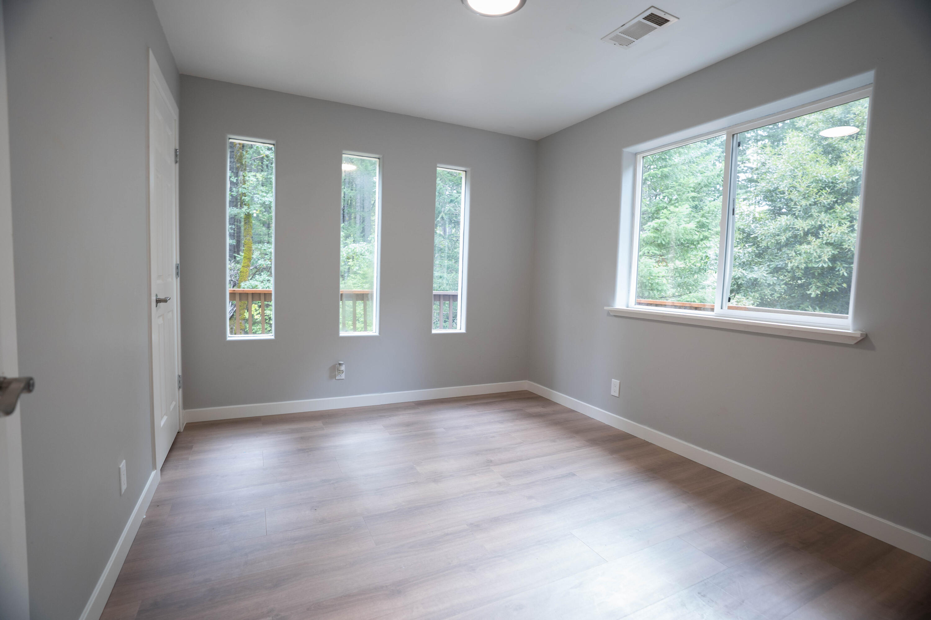 709 Pinewood Way Cave Junction, OR 97523 - Photo 15 of 24 a view of an empty room with wooden floor and a window