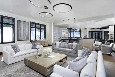 a kitchen with stainless steel appliances granite countertop a stove top oven a sink dishwasher a dining table and chairs with wooden floor