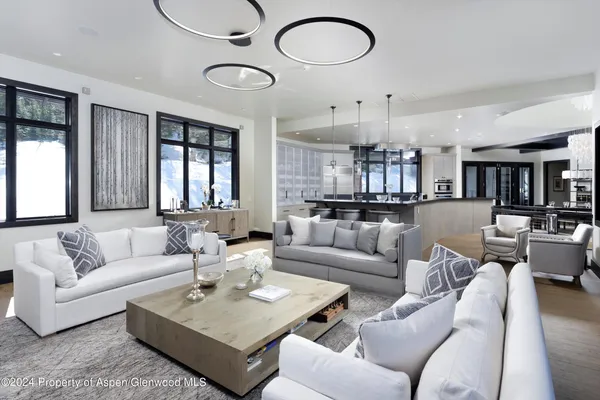 a kitchen with stainless steel appliances granite countertop a stove top oven a sink dishwasher a dining table and chairs with wooden floor