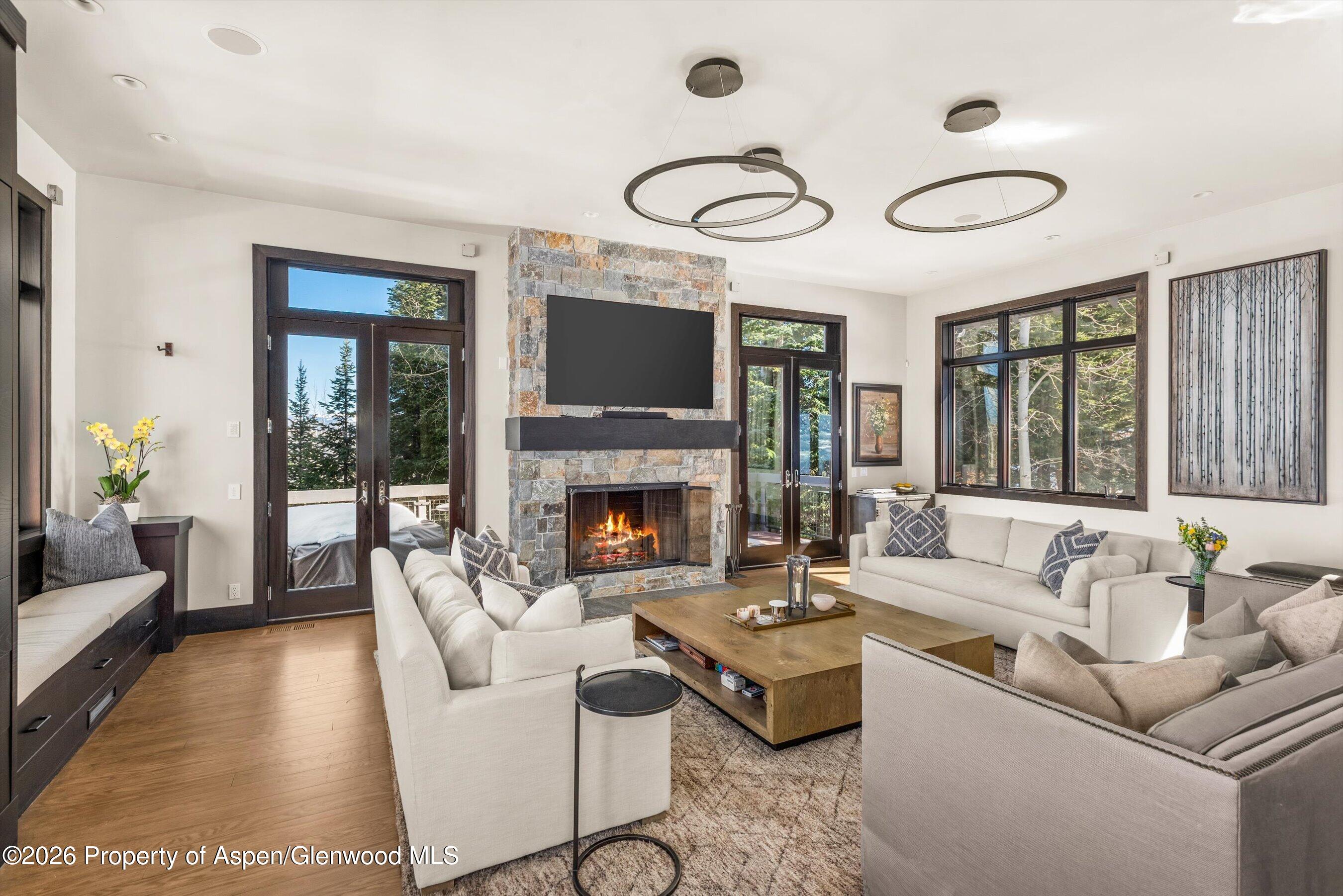 32 Elk Ridge Lane Snowmass Village, CO 81615 - Photo 16 of 58 a living room with furniture a large window and a fireplace