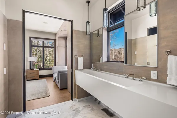 a bathroom with a tub a sink and a large mirror